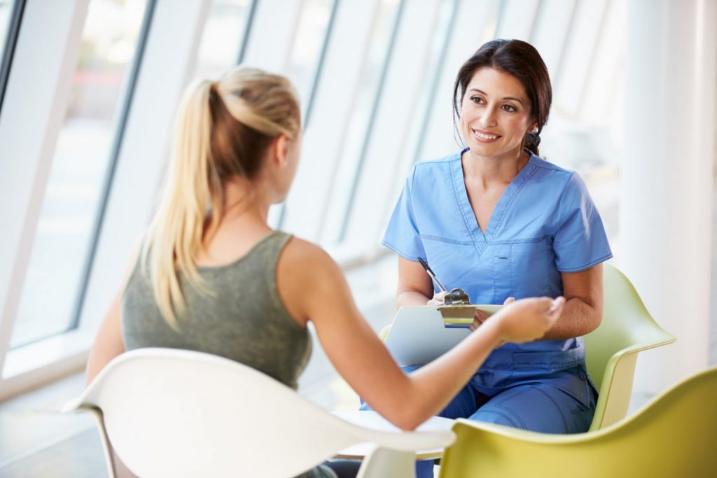 Image of female doctor speaking with female patient in medical office.